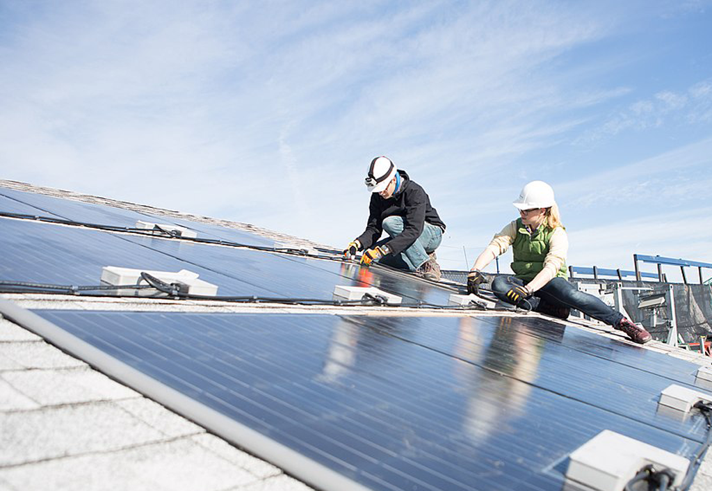 Monteure installieren Solarpanele auf einem Dach